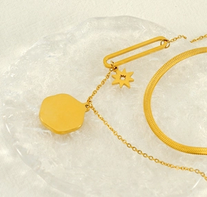 Macro detail of French vintage double-layer gold necklace with star and oval charms