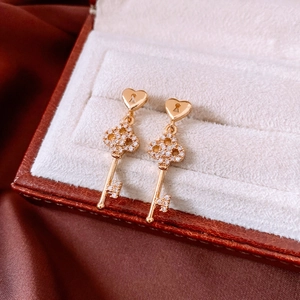 Detailed macro of 18k gold plated key earrings with heart lock and micro zircon inlay