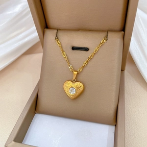 Golden heart pendant necklace with honeycomb texture in a luxury jewelry gift box