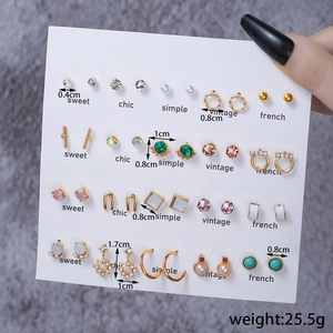 Detail of 20-pair earring set featuring gold-toned studs, pearls and colorful pendants