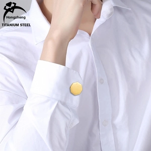 Close-up of luxury gold octagon titanium steel cufflinks on a white dress shirt sleeve