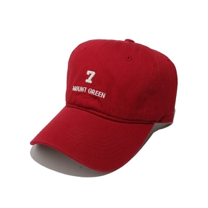 Detailed close-up of red cotton baseball cap with white 7 MOUNT GREEN embroidery