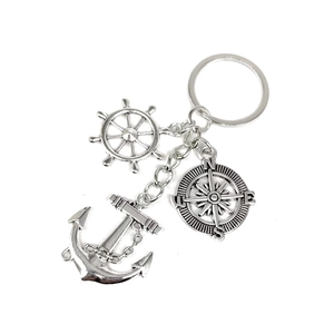 Close-up of nautical silver metal keychain with ship wheel, anchor, and compass charms