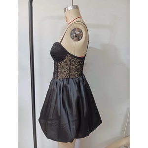 Détail du corsage en dentelle noire et jupe boule en satin sur une robe de soirée