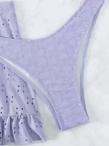 Detailopname van de lichtpaarse bikini-set met oogje-breitextuur en ruches details