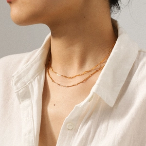 Collier double rangée en acier inoxydable doré minimaliste sur une clavicule