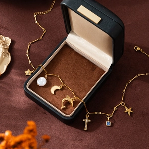 18K gold plated stainless steel necklace with pearl moon and cross charms in a jewelry box