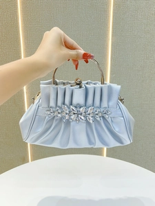 Detailed view of silver-blue evening clutch with silk pleats and crystal flower cluster