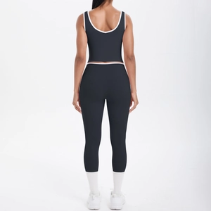 Rear view of black yoga set with white contrast trim and crossover high waist leggings