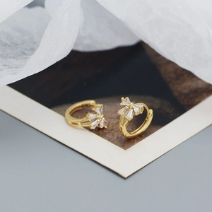 Macro shot of elegant gold bow stud earrings featuring sparkling cubic zirconia stones