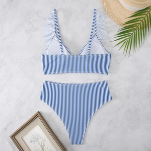 Close-up of blue and white striped bikini with ruffle straps and high waist on marble