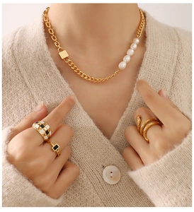 Detail view of 18K gold plated chunky chain necklace with pearls and designer rings on model