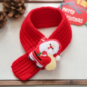 Close-up of red knitted Christmas pet scarf with plush Santa Claus and festive pinecones