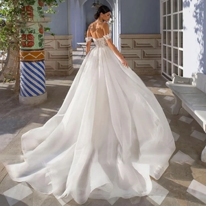 Elegant back view of off-shoulder bridal gown with lace embroidery and long tulle train