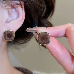 Detailed view of vintage square gold-rimmed earrings with deep brown velvet flocking inlay