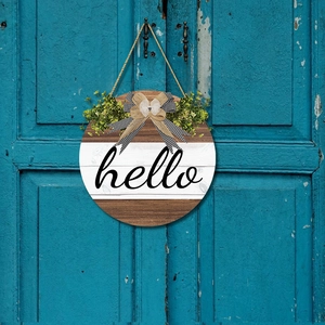Rustic round wooden Hello sign with buffalo plaid bow and greenery on blue door