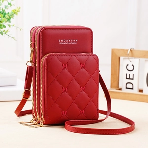 Close-up of red quilted phone bag with three zippers and butterfly embroidery detail