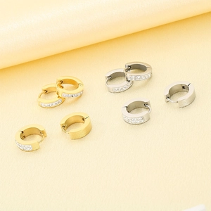 Detailed view of luxury gold and silver stainless steel earrings with sparkling diamonds