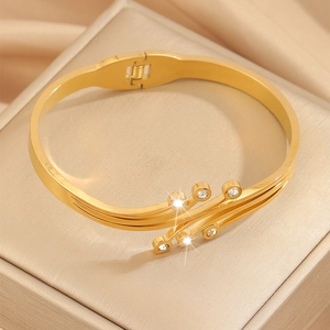 Close-up of gold titanium steel bangle with sparkling diamonds on a jewelry box