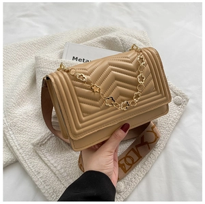 Detail of khaki chevron quilted crossbody bag with gold flower chain and wide logo strap