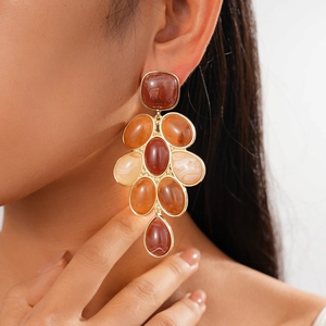 Vintage geometric gold earrings with large orange resin stones in a bohemian statement style