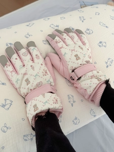 Detail of pink ski gloves with cute cartoon bear prints and adjustable wrist straps