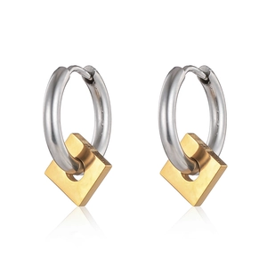 Close-up of hip hop earrings featuring silver rings and gold geometric block pendants