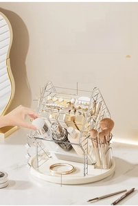 Rotating makeup organizer with metal frame showing brush holders and tiered storage compartments