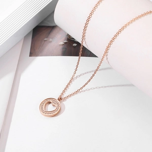 Macro view of rose gold round heart pendant featuring sparkling pavé crystals
