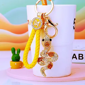 Macro detail of golden snake keychain with rhinestones and yellow braided rope charm