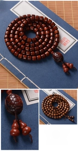 Macro view of sandalwood beads with turtle charm and gourd pendants on silk thread