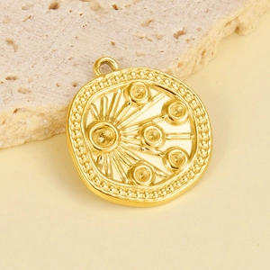 Detail of round gold stainless steel pendant with radial pattern and stone settings
