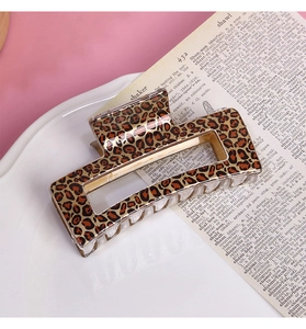 Detailed view of square leopard print hair claw clip on white textured background