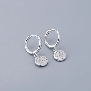 Macro shot of silver S925 sterling silver hoop earrings with vintage Indian head charms