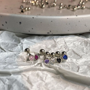 Macro shot of heart-shaped zircon earrings with milgrain edge and screw-back detail