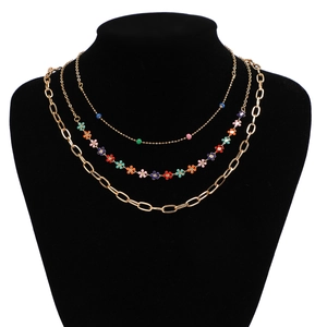 Detailed layered necklace set with gold chains, colorful beads and small flower charms