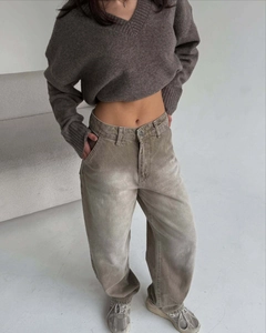 Gros plan d'un pantalon rétro à jambes larges kaki avec un pull en tricot à col en V