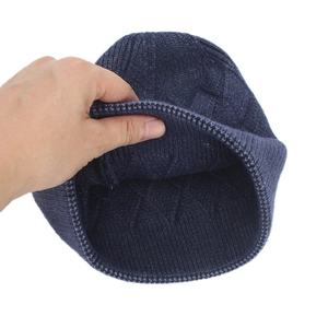 Detail of navy blue knitted beanie showing thick core-spun yarn and diamond pattern