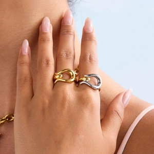 Detail of minimalist 18K gold and bicolor titanium steel rings on model hand