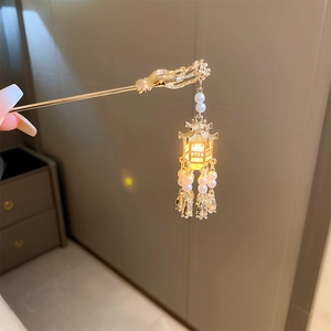 Détail de l'épingle à cheveux dorée avec lanterne lumineuse et glands de perles élégants