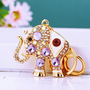 Macro detail of elephant keychain with sparkling purple crystals and gold metal finish
