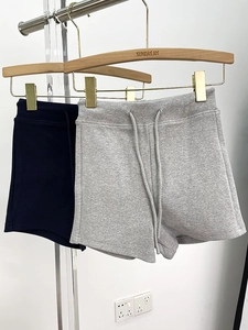 Detail of high waisted yoga shorts with adjustable drawstring in grey and black knit fabric