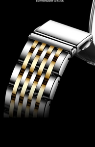 Macro detail of silver and gold two-tone stainless steel watch strap with fold-over clasp