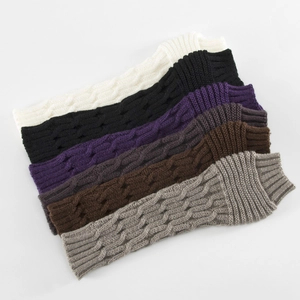 Close-up of cable knit arm warmers in multiple colors with textured stitch details