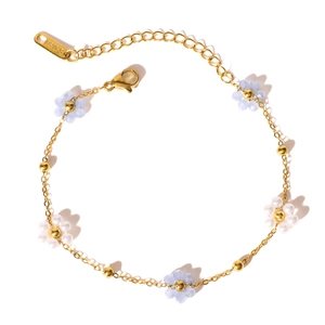 Elegant gold stainless steel bracelet featuring delicate blue and white beaded floral charms