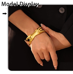 Detail eines kreativen Armreifs in Frauenform mit 18K Vergoldung an einem Handgelenk