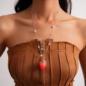 Close-up of a resin strawberry pendant with white pearls and silver star on a metal chain