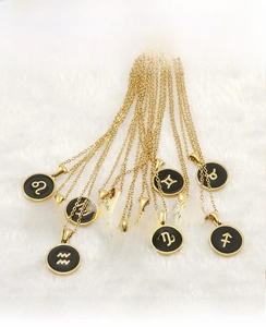 Détails de pendentifs zodiaque plaqués or 18K posés sur une fausse fourrure blanche