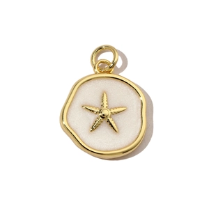 Detail of a golden starfish charm with pearlescent white enamel for jewelry making