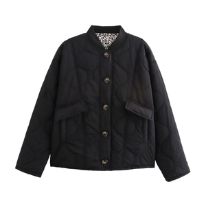 Detail of black quilted jacket featuring a stylish leopard print lining and button closure